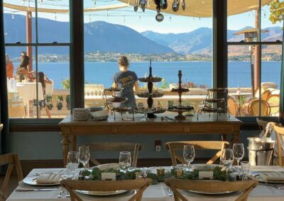 Elegant dining set-up with a view of a serene lake and mountains, ready for a buffet service.