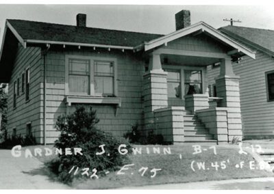Black and white photograph of a modest single-story house with handwritten annotations at the bottom.